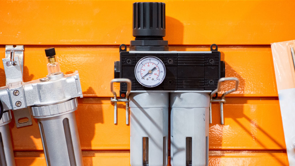 Appareil de mesure de la qualité de l'air posé sur un établi industriel avec équipements en arrière-plan