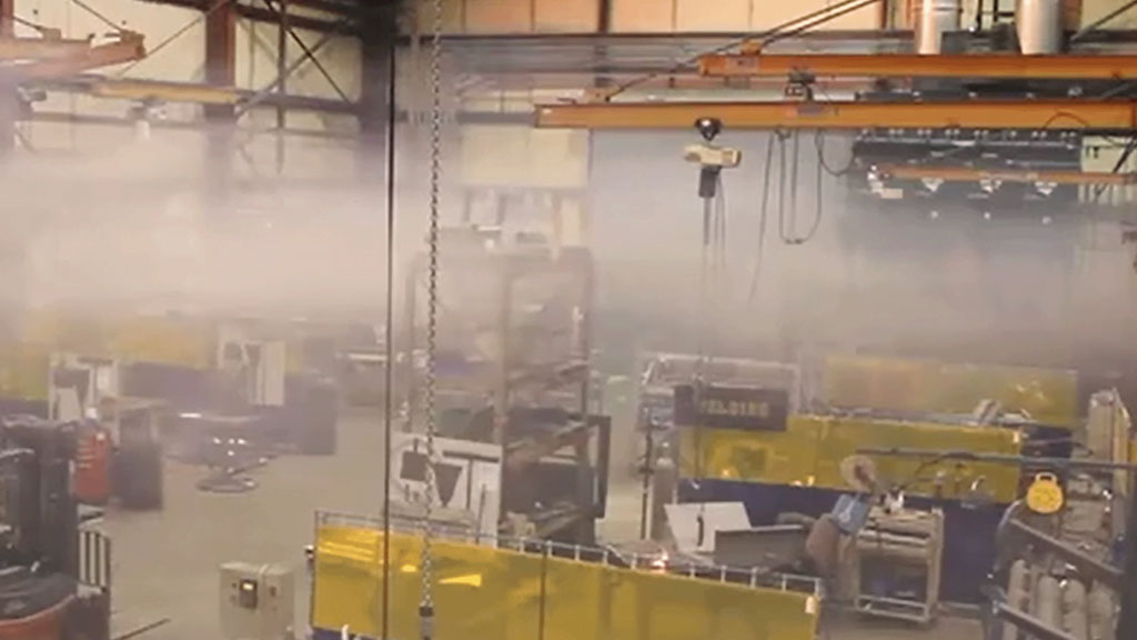 Particules de poussière visibles dans un rayon de lumière traversant un atelier de métallurgie