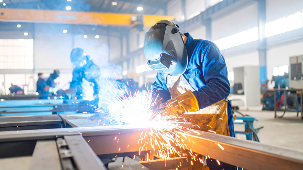 Travailleur concentré sur sa tâche dans un atelier industriel moderne et bien ventilé